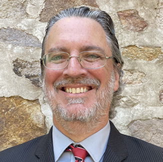 Portrait of Kenneth Kinter (a male with gray hair, wearing glasses and a suit and tie)